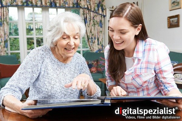 Grandmother Looking At Photo Album With Teenage Granddaughter Digitalisierung kompletter Fotoalben