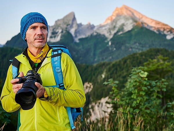 Nikon School mit neuem Herbst/Winter-Programm. Mann mit Nikon-Kamera bei Landschaftsfotografie