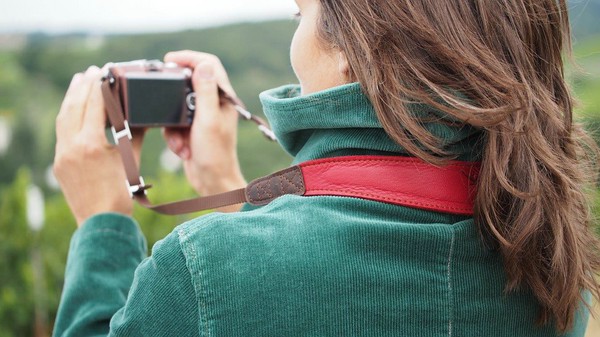 Fotografin hält Kamera mit EDDYCAM Kameragurt. Gut erkennbar: ergonomischer Sitz im Nacken