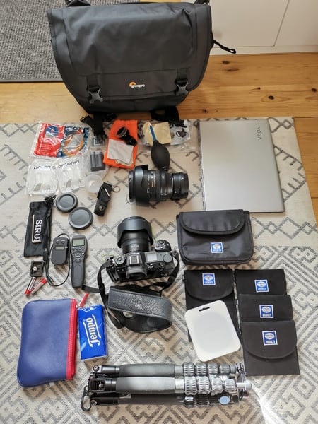 Messengertasche ProTactic MG 160 AW II von Lowepro, davor auf dem Boden die Fotoausrüstung, die in die Tasche passt
