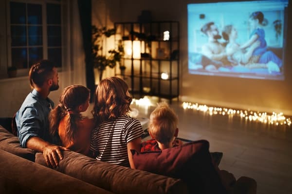 Mutter, Vater und Kinder schauen Abends zu Hause Fotografien auf dem Fernsehen an - Dia-Abend