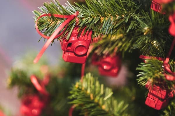 Weihnachtsbaum geschmückt mit kleinen Figuren von roten Fotoapparaten