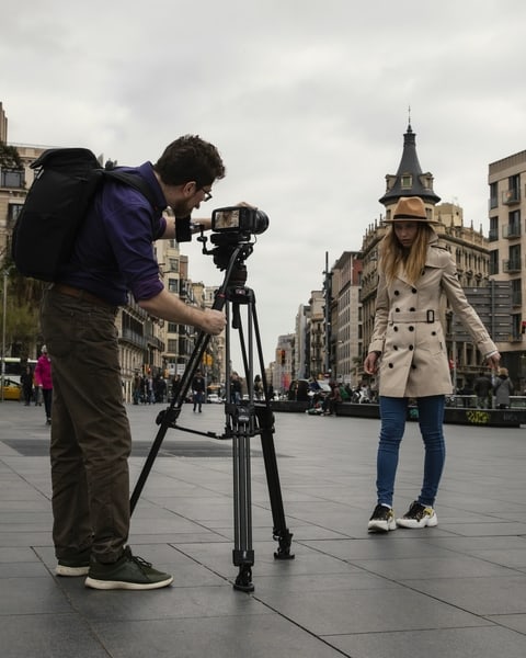 Mann filmt mit Kamera auf Manfrotto Stativ ein Model in einer Innenstadt