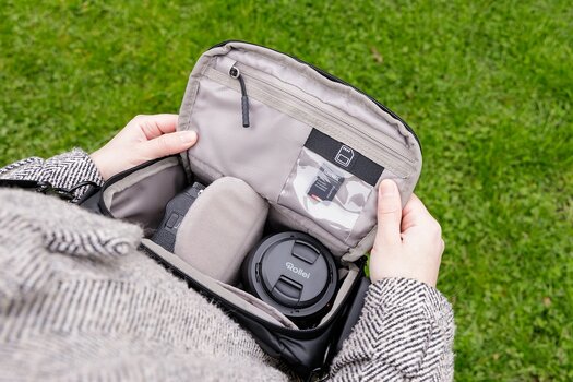 Blick in die geöffnete Rollei Fotoliner Ocean Bag M mit Kamera, Objektiv und Speicherkarte. Blick in die geöffnete Rollei Fotoliner Ocean Bag M mit Kamera, Objektiv und Speicherkarte.