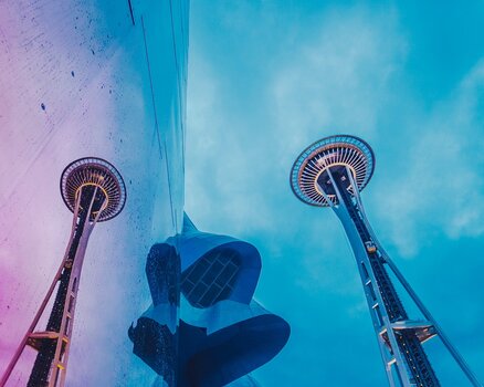 Die futuristische Space Needle in Seattle aus extremer Froschperspektive, gespiegelt in einer modernen Glasfassade. Die futuristische Space Needle in Seattle aus extremer Froschperspektive, gespiegelt in einer modernen Glasfassade.