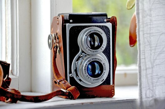 Historische Ricoh-Zweiäugige Spiegelreflexkamera auf einem Fensterbrett – Vintage-Kamera als Symbol für die Geschichte der Fotografie.