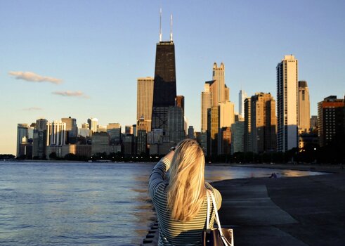 Fotografin blickt auf die Skyline von Chicago und fotografiert die Stadt als Symbol für Fernweh und Reisefotografie.