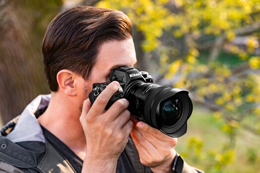 Fotograf nutzt das TAMRON 12-20mm F2.8 an einer Nikon Z6 III im Freien. Fotograf nutzt das TAMRON 12-20mm F2.8 an einer Nikon Z6 III im Freien.