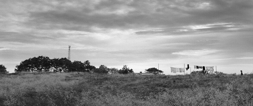 Weite Schwarz-Weiß-Landschaft der Insel Hiddensee mit dramatischem Himmel und Horizont.