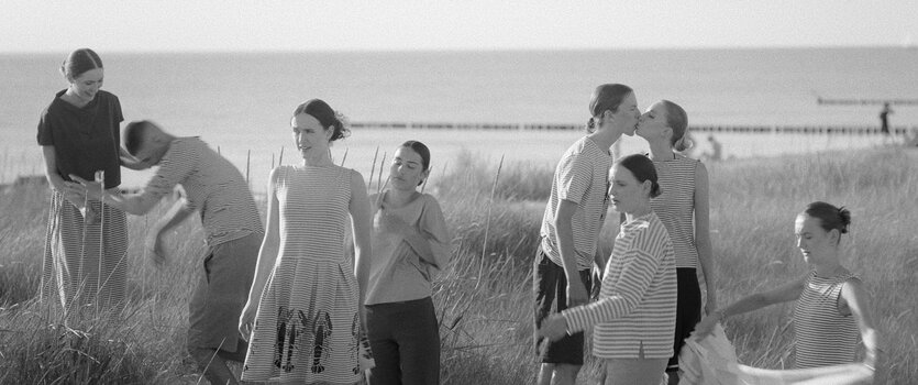 Menschen am Strand von Hiddensee in einer atmosphärischen Schwarz-Weiß-Szene aus dem Dokumentarfilm.