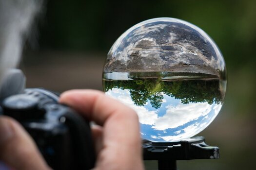Fotografieren einer Landschaft durch eine Glaskugel mit umgekehrter Spiegelung