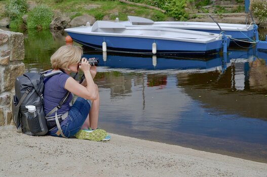 Fotografin unterwegs mit Kamera und großem Fotorucksack