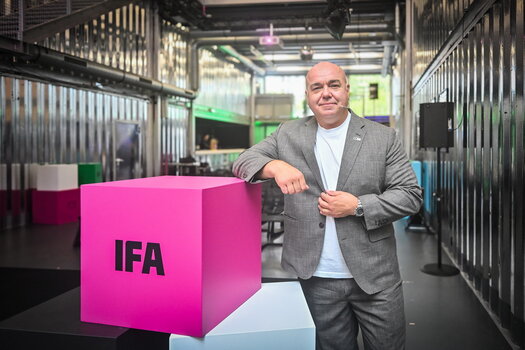 Leif Lindner neben einem großen pinkfarbenen IFA-Würfel 