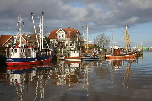 Fischerboote in einem Hafen spiegeln sich auf der Wasseroberfläche