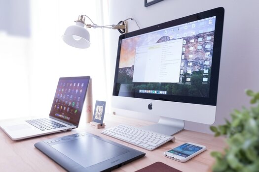 Heller Computerarbeitsplatz mit Monitor, Laptop, Grafiktablett und Smartphone Heller Computerarbeitsplatz mit Monitor, Laptop, Grafiktablett und Smartphone