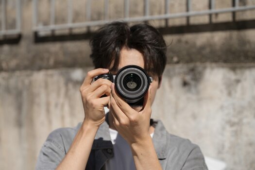 Fotograf mit Kamera und Viltrox AF 35mm F1.4 Pro für Nikon Z, frontal auf die Objektivlinse fotografiert. Fotograf mit Kamera und Viltrox AF 35mm F1.4 Pro für Nikon Z, frontal auf die Objektivlinse fotografiert.