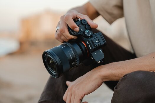Sony-Alpha-Kamera mit montiertem Viltrox AF 35mm F1.4 Pro in den Händen eines Fotografen. Sony-Alpha-Kamera mit montiertem Viltrox AF 35mm F1.4 Pro in den Händen eines Fotografen.