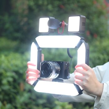 Hände halten LUMIS U-Light von Rollei mit montierter Kamera und Mikrofon. Hände halten LUMIS U-Light von Rollei mit montierter Kamera und Mikrofon.