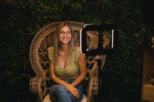 Model wird in Korbsessel sitzend vor grüner Pflanzenwand fotografiert. Anwendungsbeispiel für LUMIS U-Light von Rollei