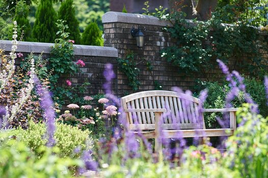 Bank im Garten, im Vordergrund Blumenbeete