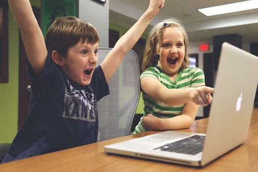 sich freuende Kinder vor einem Laptop sich freuende Kinder vor einem Laptop