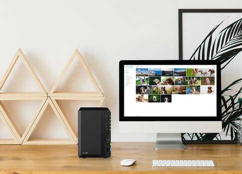 Symbolbild. Synology NAS auf heimischem Schreibtisch mit Monitor, Tastatur, Maus und Wohndeko. Artikel zum Thema: Sicheres Arbeiten im Homeoffice.