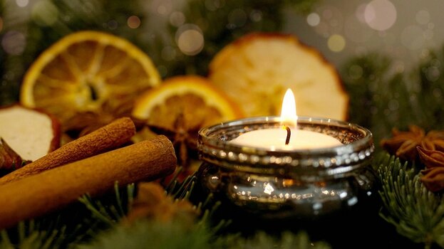 Adventsgesteck mit Zimtstangen, Teelicht und getrockneten Orangenscheiben