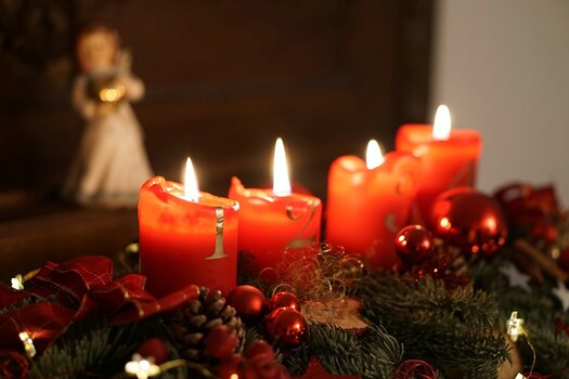 4 rote Kerzen im Adventsgesteck brennen