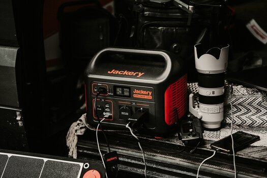 Jackery Explorer 1000 in offenem Kofferraum neben Fotoequipment