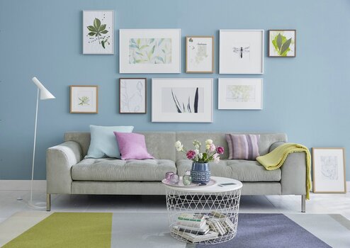 Wandhaengung ueber Sofa - helle Motive auf blauer Wand Wandhaengung ueber Sofa - helle Motive auf blauer Wand