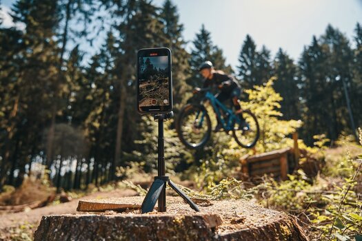 Mountainbiker im Sprung wird mit dem Smartphone auf FIDLOCK VACUUM mini tripod gefilmt