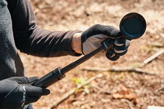 Zwei behandschuhte Hände ziehen das FIDLOCK VACUUM mini tripod auseinander