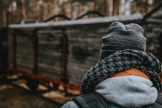 Fotograf in Winterkleidung und Rucksack auf dem Rücken mit umgehängten EDDYCAM Kameragurt 