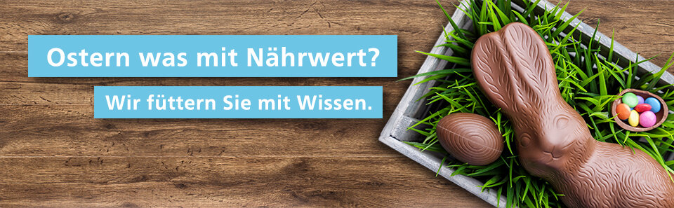 Rechts: Schokoosterhase, Schokoei und Zuckereier im Osterkorb mit grünem Gras. Links: Schriftzug Ostern was mit Nährwert? Wir füttern Sie mit Wissen.