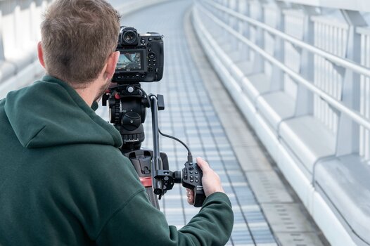 Mann fotografiert mit montiertem Fernsteuerungshandgriff MC-N10 für Nikon-Z an Kamera auf Stativ Mann fotografiert mit montiertem Fernsteuerungshandgriff MC-N10 für Nikon-Z an Kamera auf Stativ