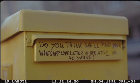 Gelber Briefkasten, Aufschrift auf der Einwurfklappe: Do you think she`ll find your whatsapp love letter in her attic in 40 years?