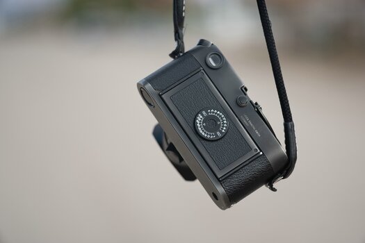 Gebrauchte Leica M6 (Rückansicht) hängt an Kameragurt 