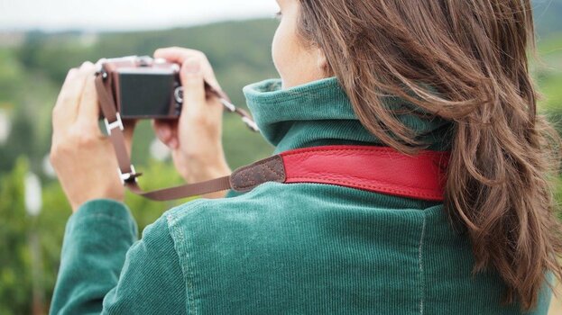 Fotografin trägt roten EDDYCAM-Kameragurt im Nacken