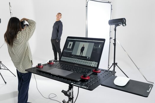 Frau fotografiert männliches Model im Studio. Im Bild u.a. die TetherGear Produkte von Manfrotto