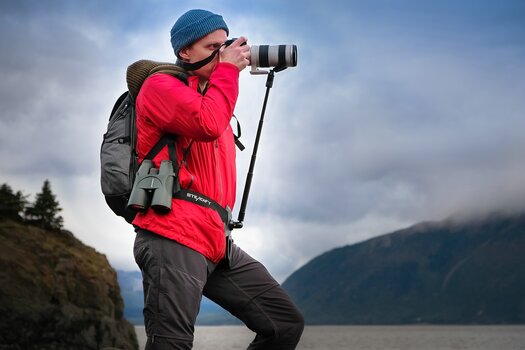 Mann mit roter Jacke und Fotorucksack fotografiert mit auf dem Steadify montierter Kamera