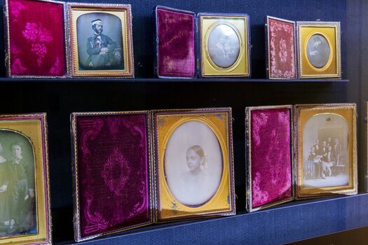 Gerahmte Daguerrotypien auf zwei Regalborden übereinander. Ausstellungsansicht. Foto: © Kunstsammlung Jena
