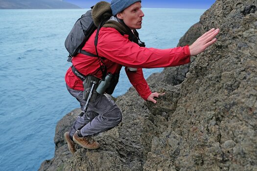 Mann hat Steadify umgebunden und klettert Felsen hinauf