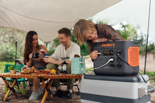 Familie beim Camping. Kind inspiziert den Jackery Solargenerator. Familie beim Camping. Kind inspiziert den Jackery Solargenerator.