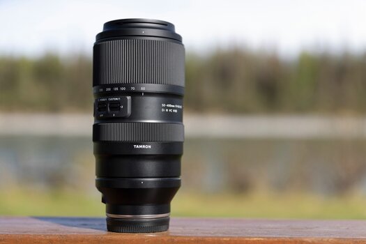 Tamron 50-400mm F/4.5-6.3 Di III VC VXD auf Holzunterlage stehend Tamron 50-400mm F/4.5-6.3 Di III VC VXD auf Holzunterlage stehend