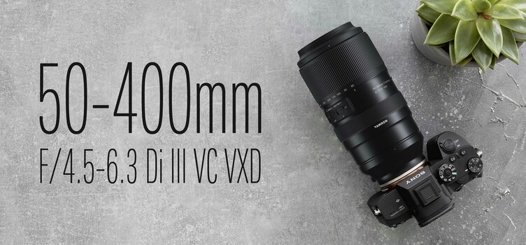 Tamron 50-400mm F/4.5-6.3 Di III VC VXD an Sony-Kamera, daneben Schriftzug mit Produktbezeichnung Tamron 50-400mm F/4.5-6.3 Di III VC VXD an Sony-Kamera, daneben Schriftzug mit Produktbezeichnung