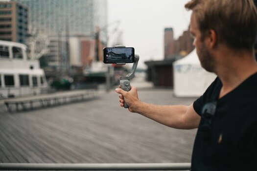 Mann hält Steady Butler Mobile 3 SE mit montiertem Smartphone in der Hand - Vorderansicht
