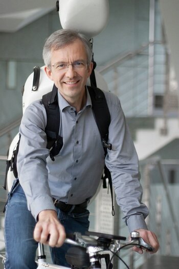 Joachim Fiedler auf dem Fahrrad mit Cello auf dem Rücken