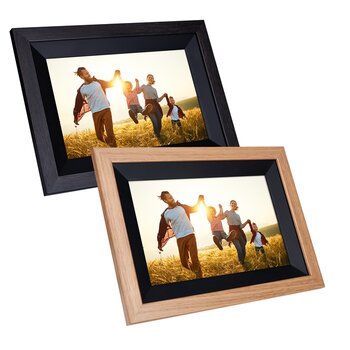 ein schwarzer und ein weißer digitaler Bilderrahmen auf weißem Hintergrund mit denselben Fotos, auf denen eine Familie sich an den Händen haltend durch ein Getreidefeld läuft.