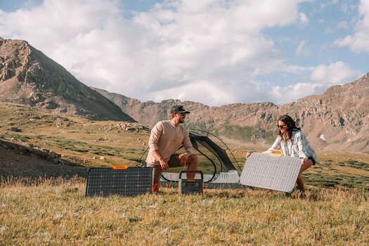 Paar baut Solarpanel und Solargenerator von Jackery im Freien auf Paar baut Solarpanel und Solargenerator von Jackery im Freien auf