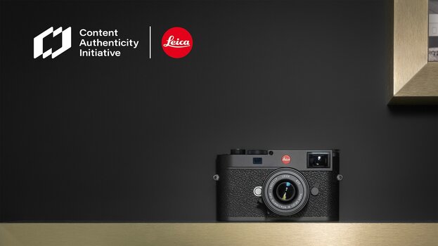 Leica-Kamera auf Holzleiste vor dunklem Hintergrund, oben Links Logos der CAI und von Leica Leica-Kamera auf Holzleiste vor dunklem Hintergrund, oben Links Logos der CAI und von Leica
